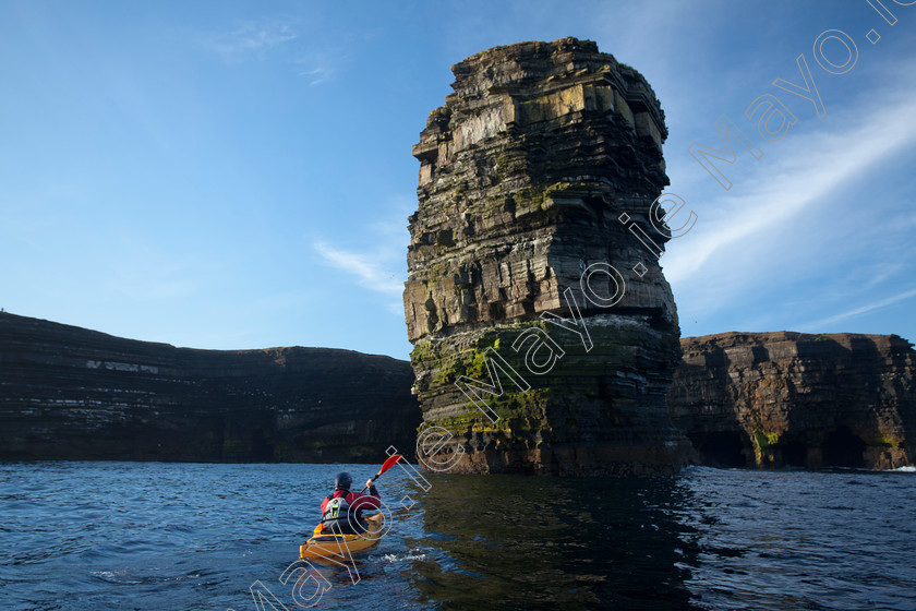 Kayaker-at-Downpatrick-Head 
 Sea kayaker beneath Dun Briste seastack, Downpatrick Head, Co Mayo, Ireland. 
 Keywords: Irish, sea, kayaking, kayaks, kayakers, canoeing, canoes, canoeists, boats, water, sports, watersports, adventure, sports, exploration, activity, activities, outdoors, pursuits, shores, shorelines, coasts, coastlines, coastal, atlantic, outdoors, scenery, scenes, cliffs, rocky, stacks, headlands, seacliffs, clifflines