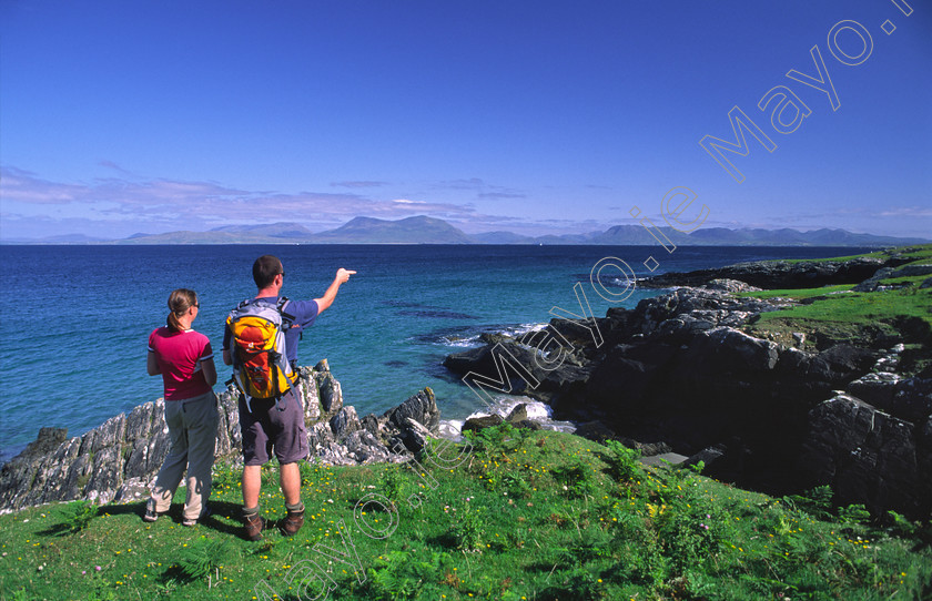 Walkers-on-Inishturk 
 Walkers looking towards the mainland from Inishturk Island, Co Mayo, Ireland. 
 Keywords: Irish, islands, shores, shorelines, coasts, coastlines, coastal, atlantic, seas, oceans, outdoors, scenes, walks, walking, walkers, hikes, hiking, hikers, treks, trekking, trekkers, outdoors, activity, activities, leisure, recreation, summer